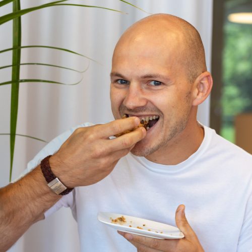 Man neemt een hap van de vegan blondie